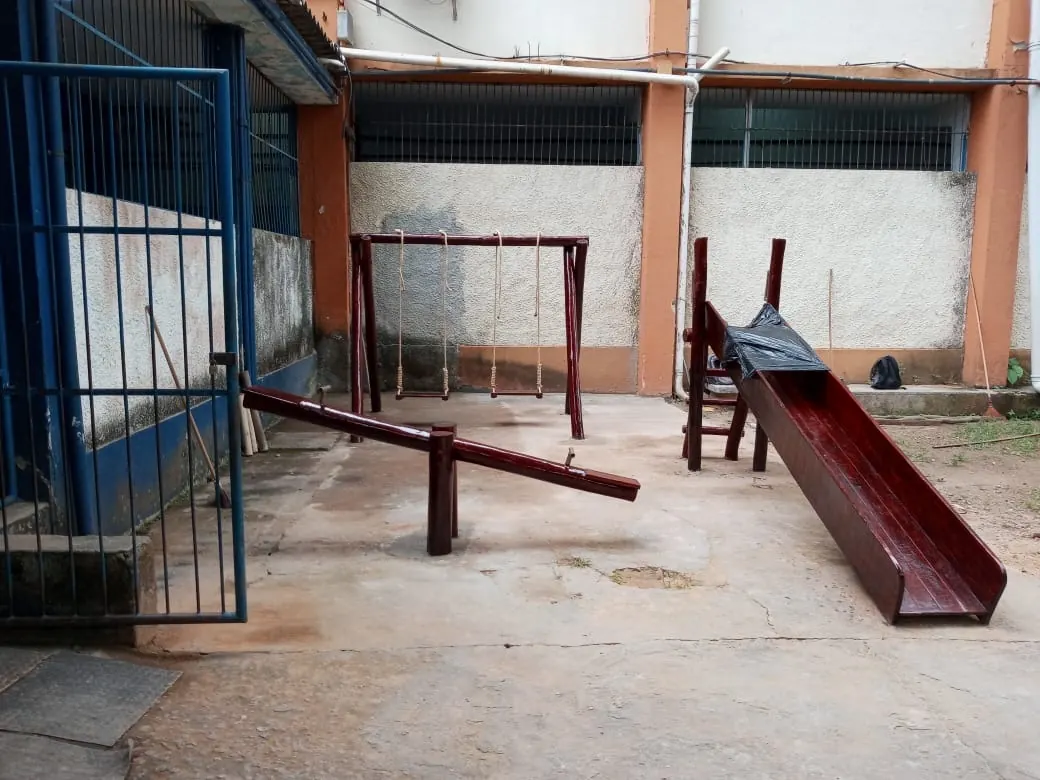 Área externa de escola com gangorra, balanços e escorregador de madeira instalados pela PHD Playground