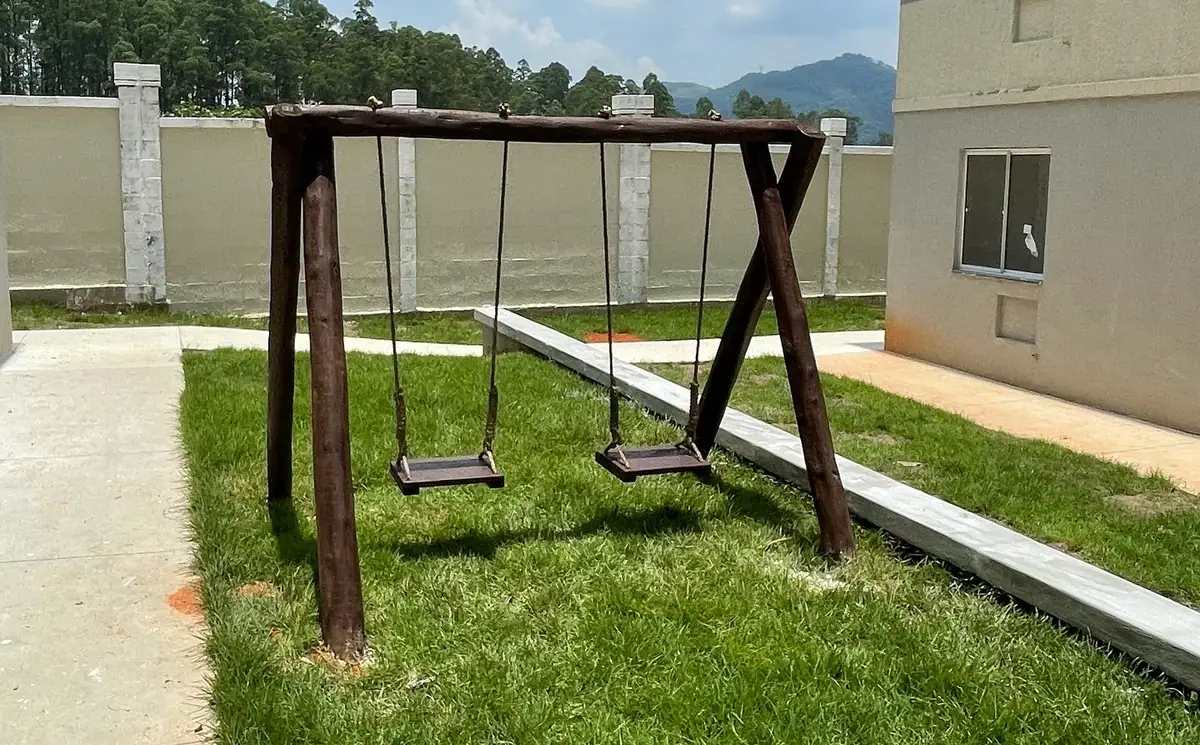 Balanço de playground em condomínio bem mantido, representando qualidade e longevidade de investimento sob medida
