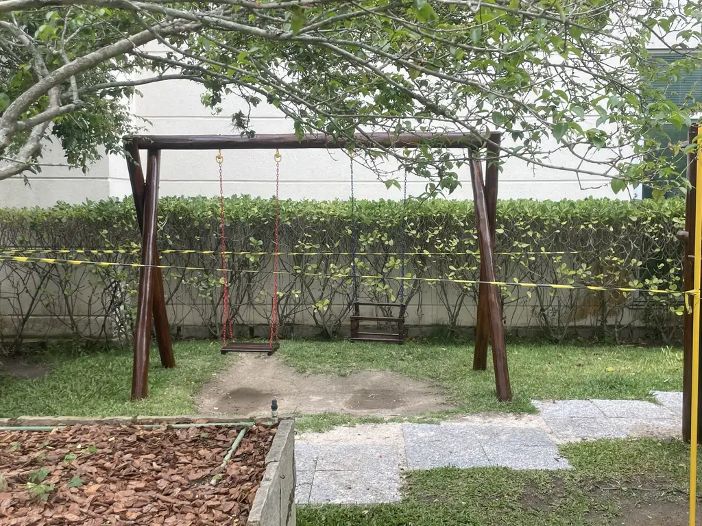 Balanço em condomínio com biofilme verde e umidade visível, mostrando degradação superficial causada por clima úmido e falta de manutenção