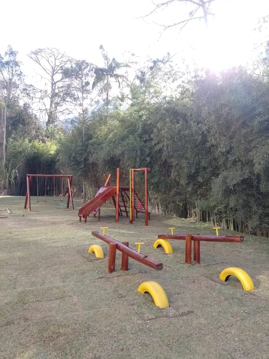Playground PHD instalado em área nivelada de sítio com gramado amplo e espaço para livre movimentação das crianças