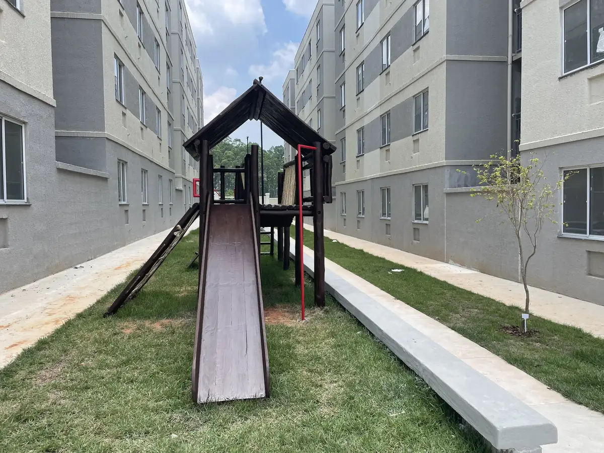 Playground de madeira de eucalipto PHD com torres, escadas e balanço em condomínio com gramado cuidado