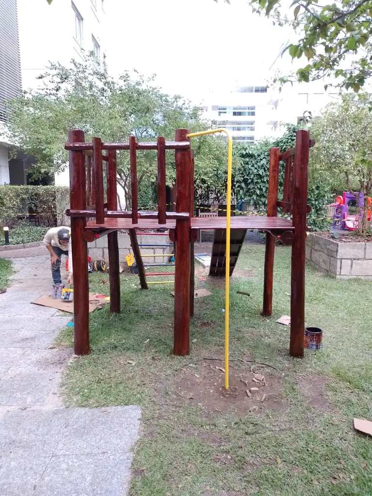 Equipe PHD Playground instalando estrutura de madeira em condomínio, mostrando etapa de montagem vertical com estrutura de eucalipto em fundação de concreto
