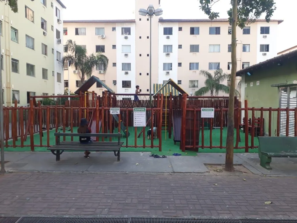 Vista geral de playground completo de madeira em condominio com piso de borracha e vários equipamentos