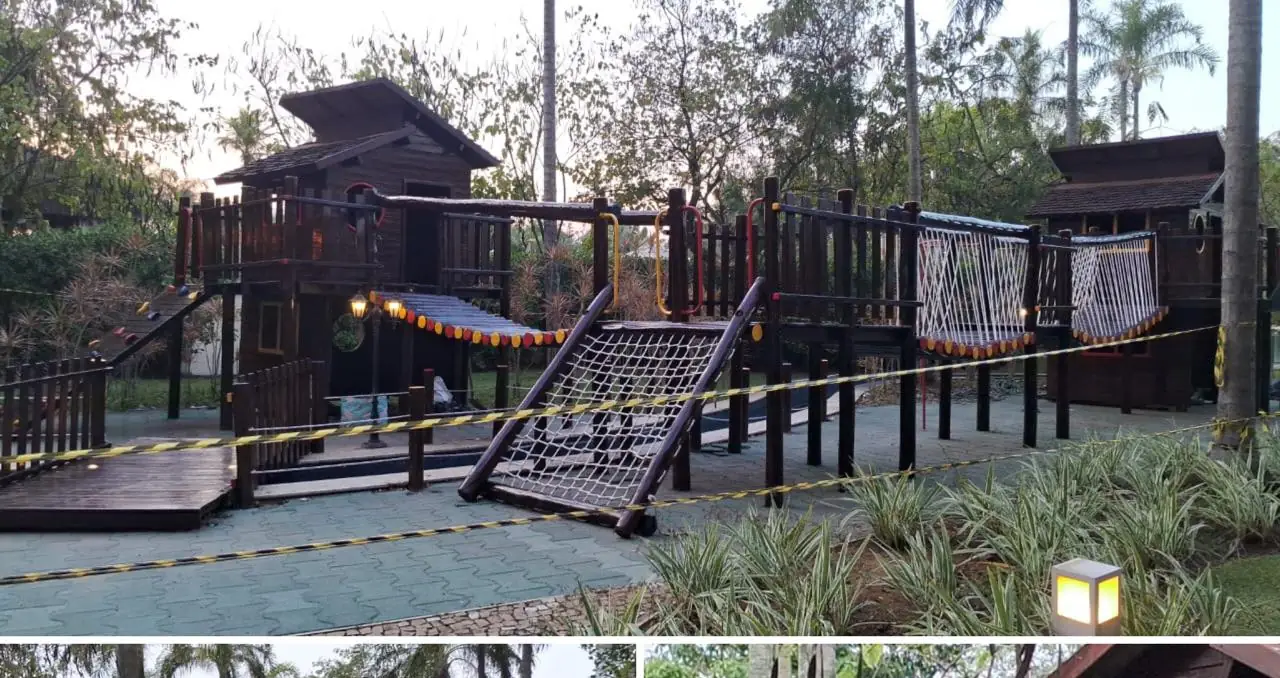 Deck de madeira com casas e pontes de corda em playground de resort, entre a vegetação