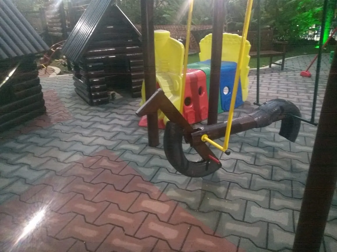 Balanco infantil de madeira em escola com piso de borracha
