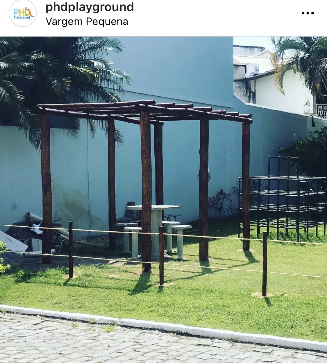 Pergolado de madeira sobre playground com gramado natural
