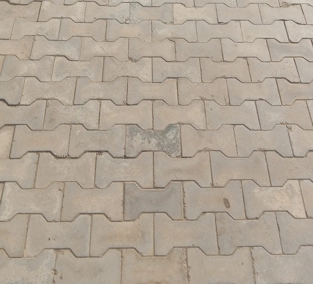 Piso intertravado de concreto cinza, tipo ossinho, em área de circulação