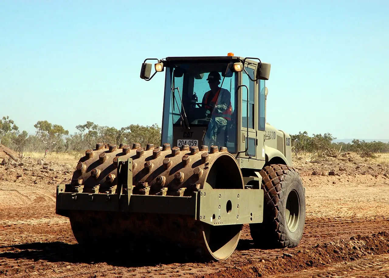 Rolo compactador de solo trabalhando em terreno terraplanado